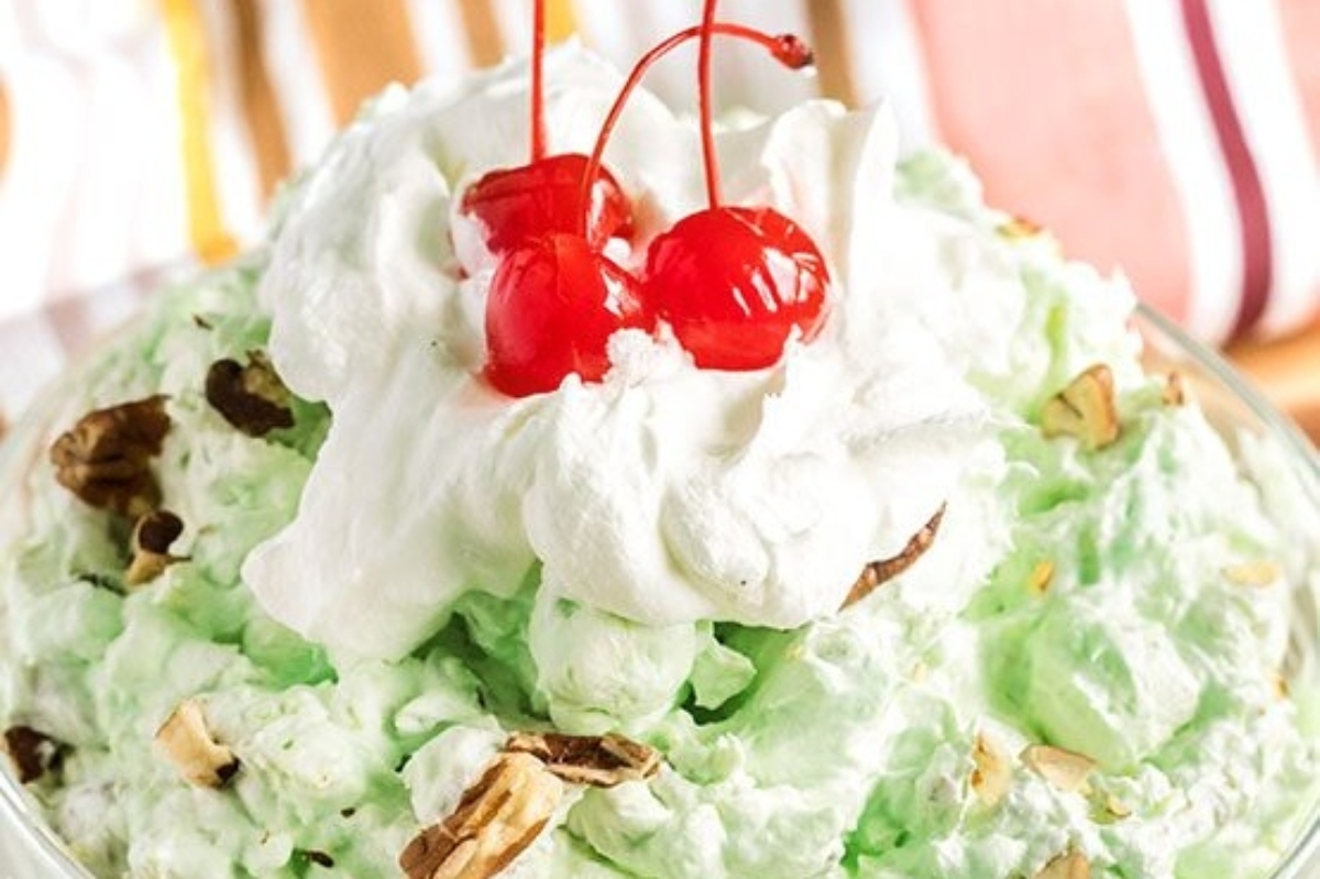 A bowl of ice cream with whipped cream and cherries.