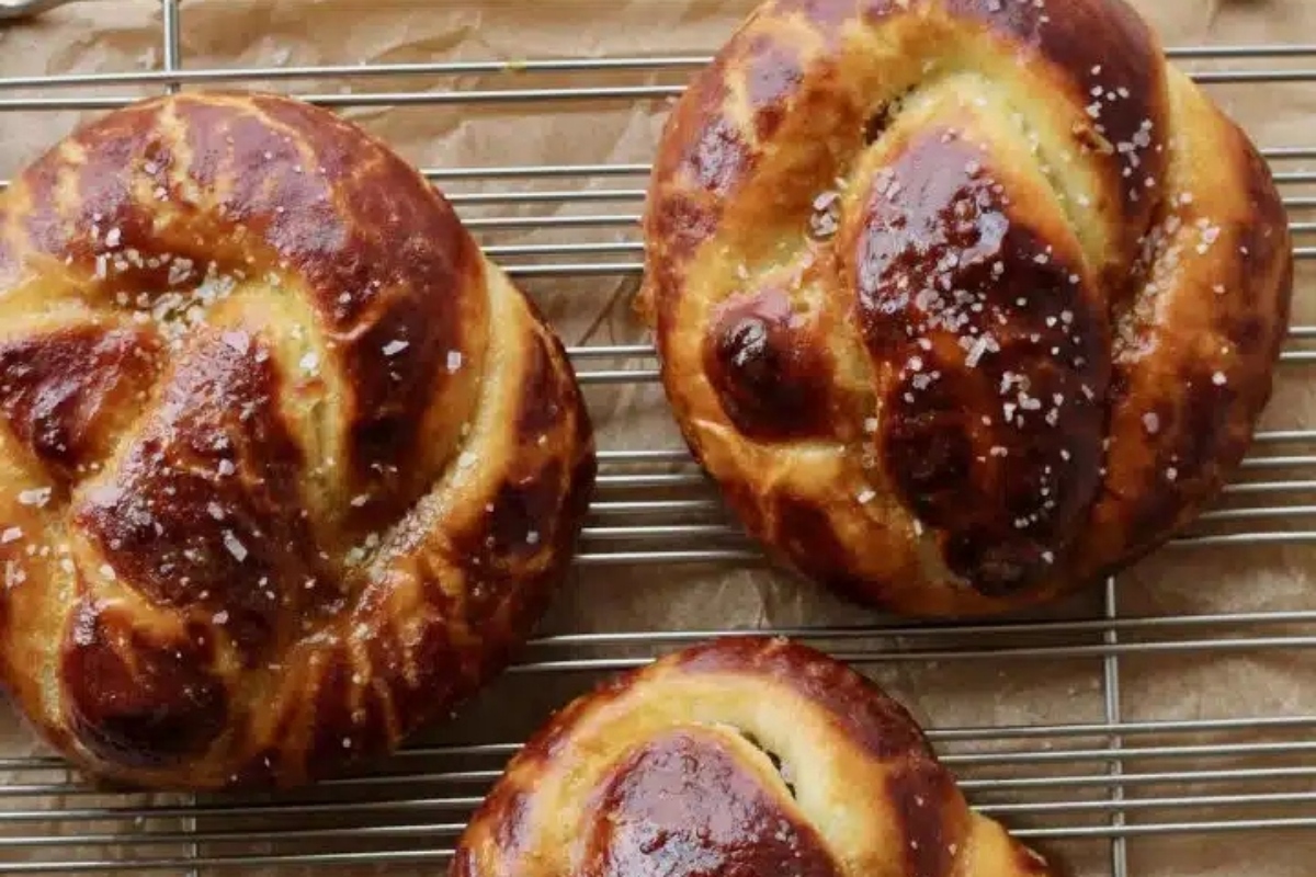 Three pretzels sitting on a cooling rack.