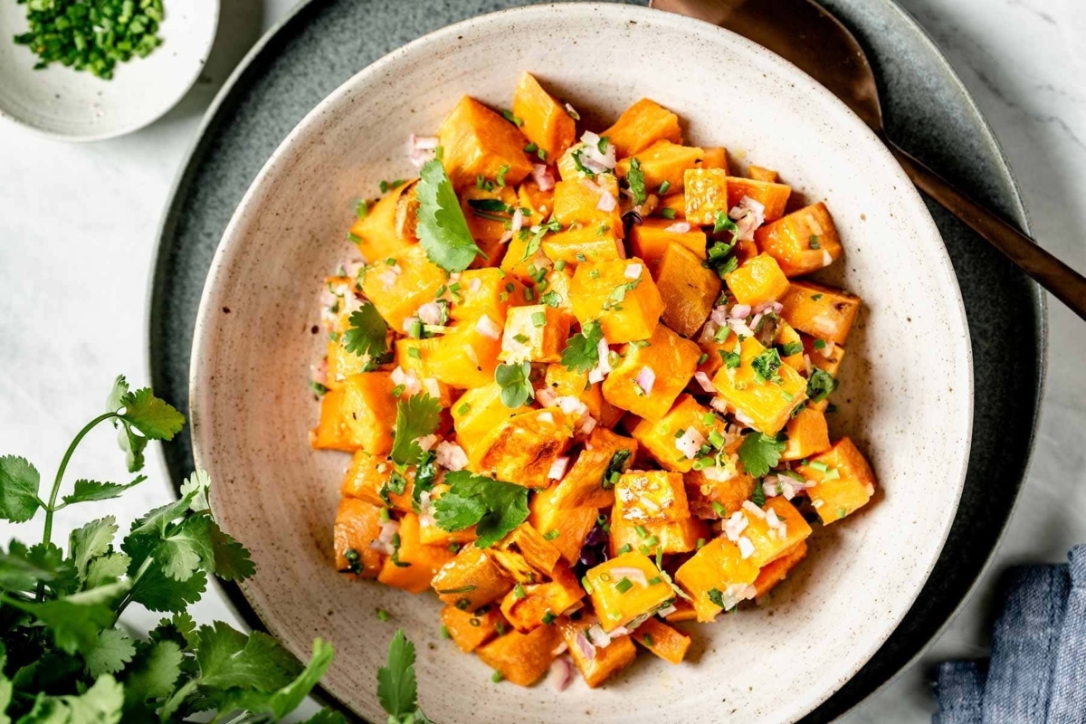 A bowl of sweet potato salad on a table.