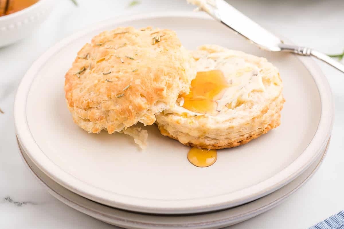 A plate of biscuits with honey on it.