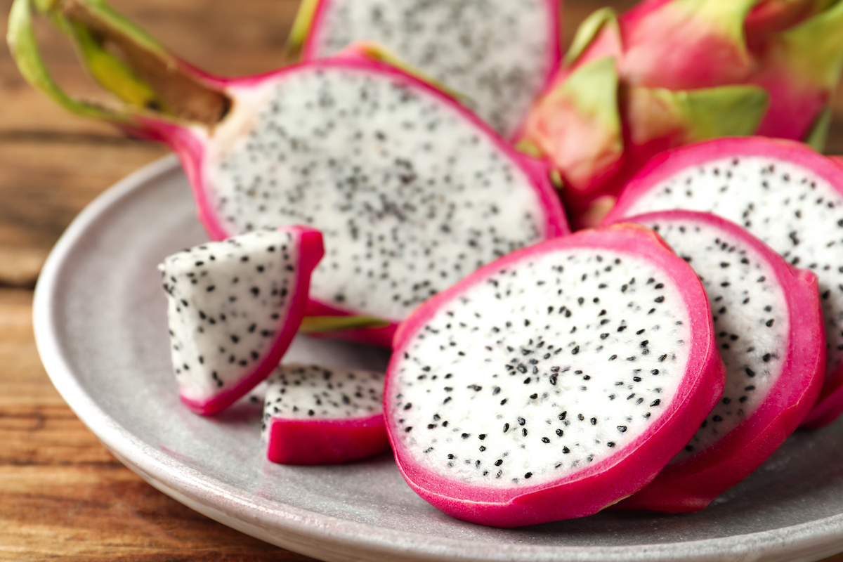 Delicious cut dragon fruit (pitahaya) on wooden table, closeup.