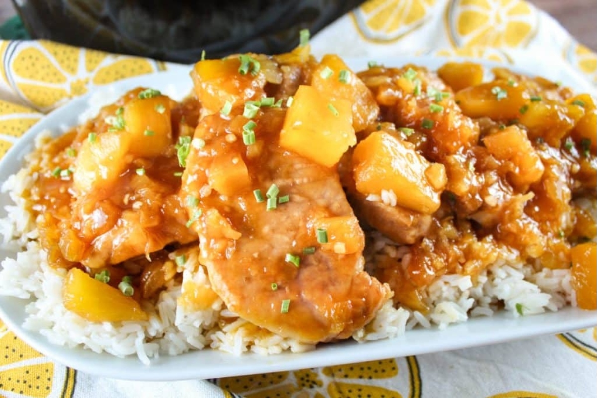 A white plate with chicken and pineapple on it.