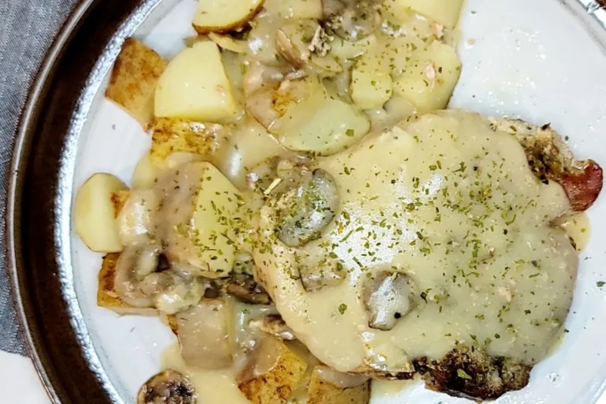 A plate with mushrooms, potatoes and gravy on it.
