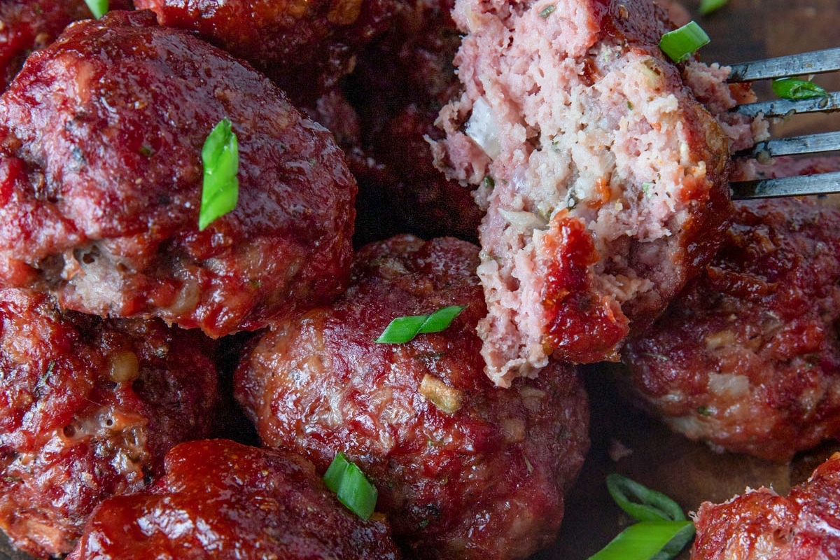 Meatballs on a wooden board with a fork.