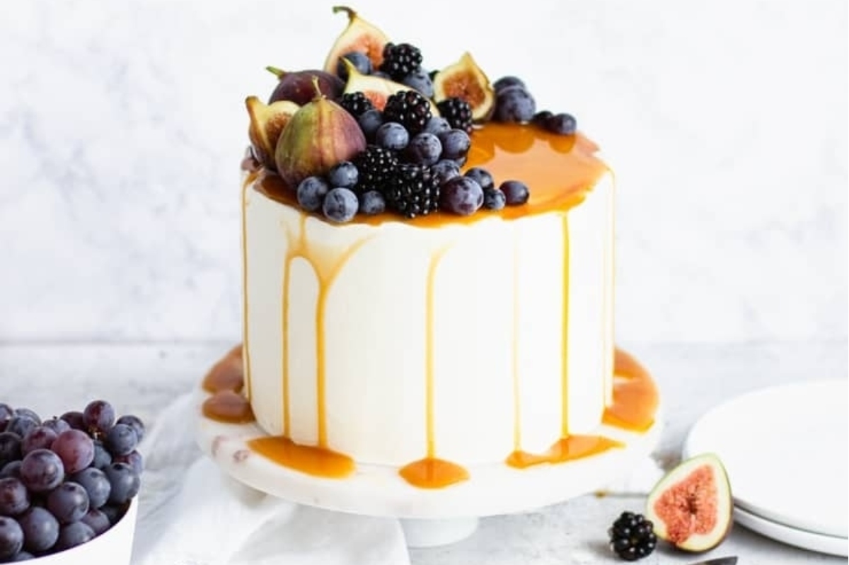 A cake with figs and blackberries on top.