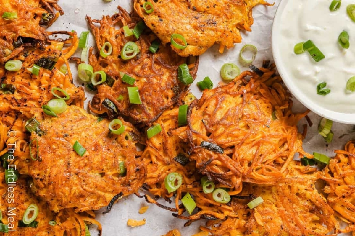 Sweet potato pancakes with sour cream and green onions.