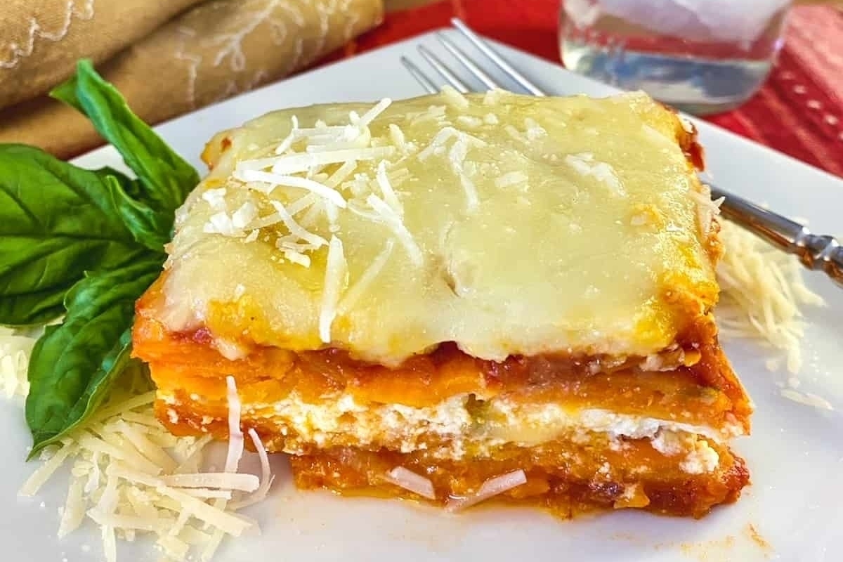 A slice of lasagna on a white plate.