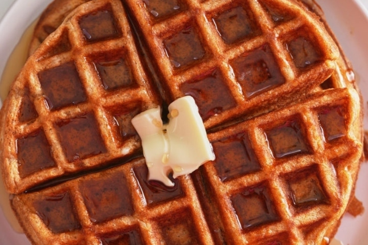 Waffles with butter and syrup on a plate.