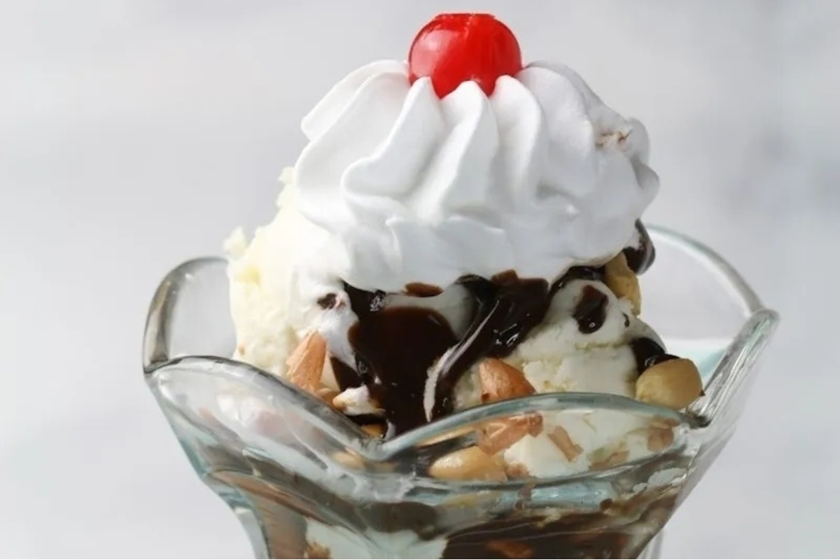 An ice cream sundae with whipped cream and a cherry on top.