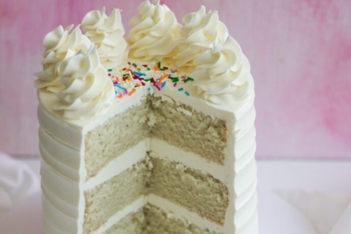 A white cake with a slice taken out of it.