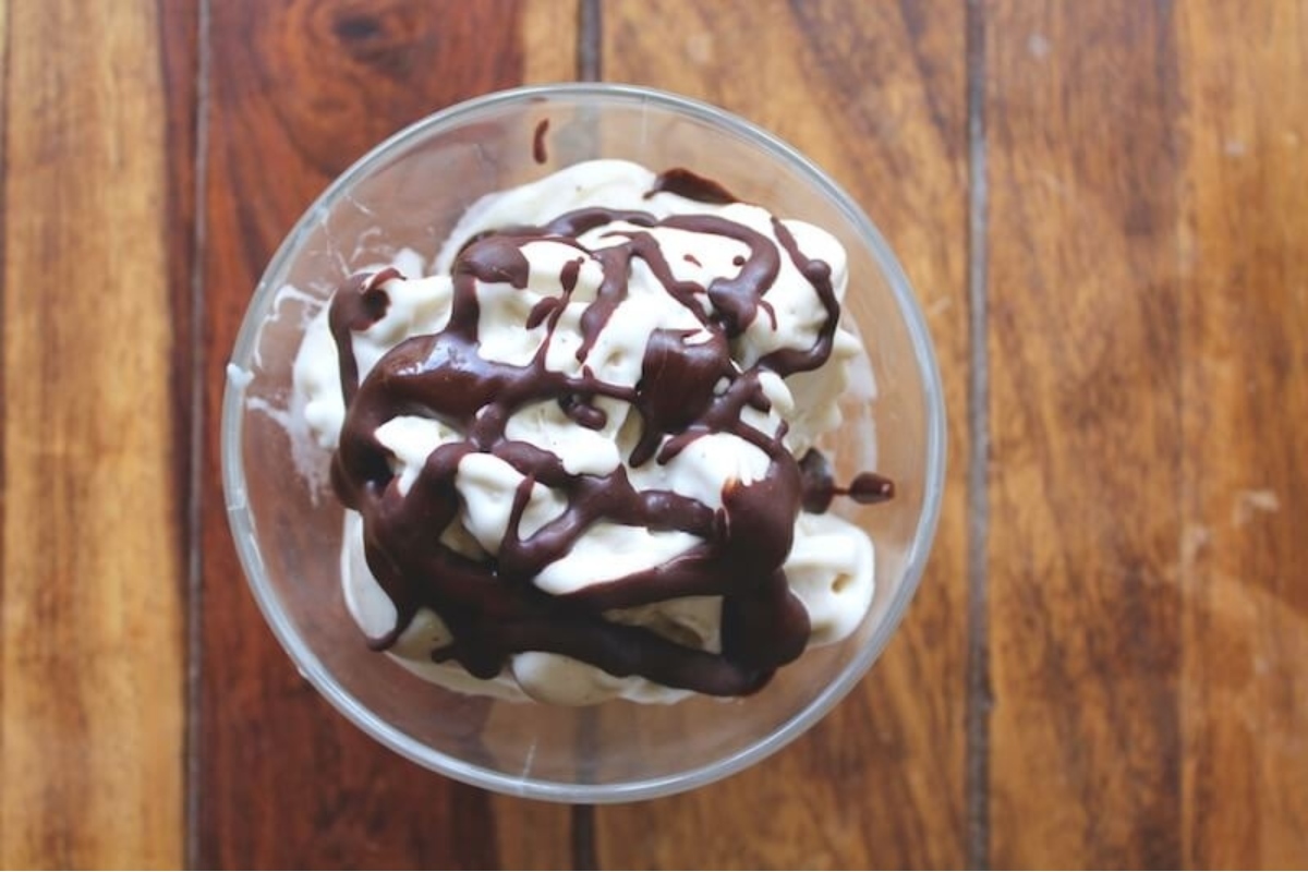 A bowl of ice cream with chocolate sauce on top.