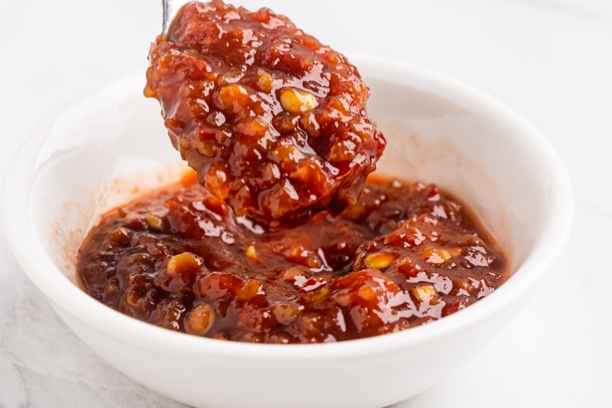 A spoonful of sauce in a white bowl.