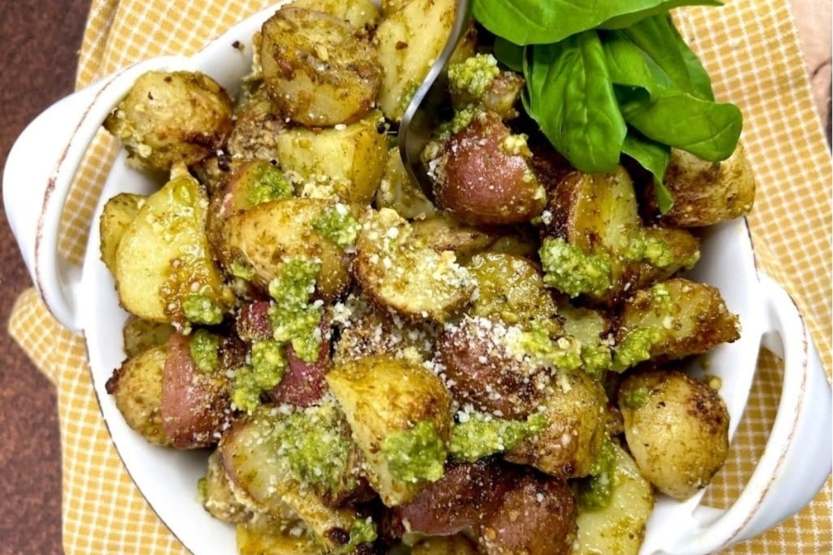 Roasted potatoes with pesto in a white bowl.