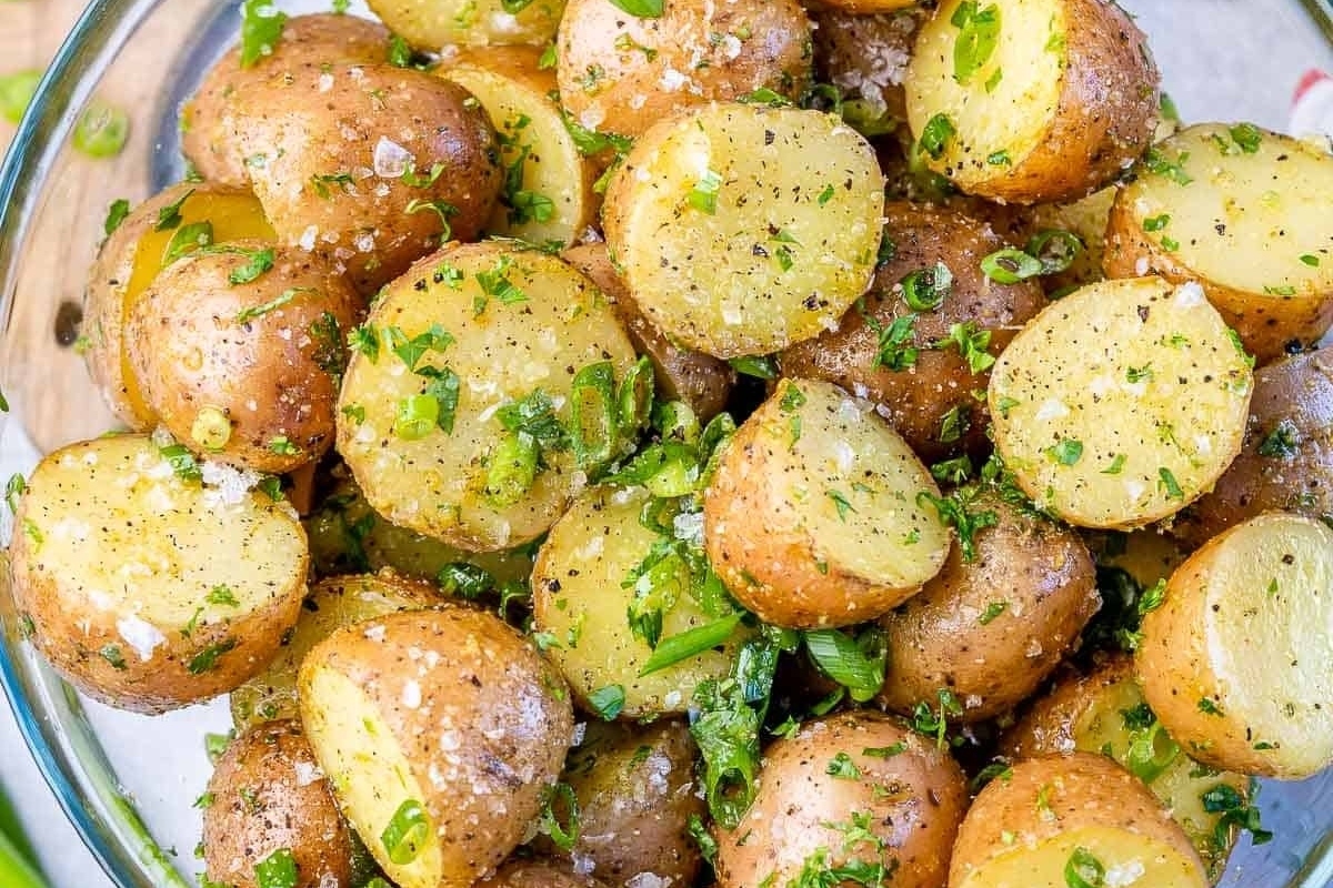 A bowl of potatoes with herbs.