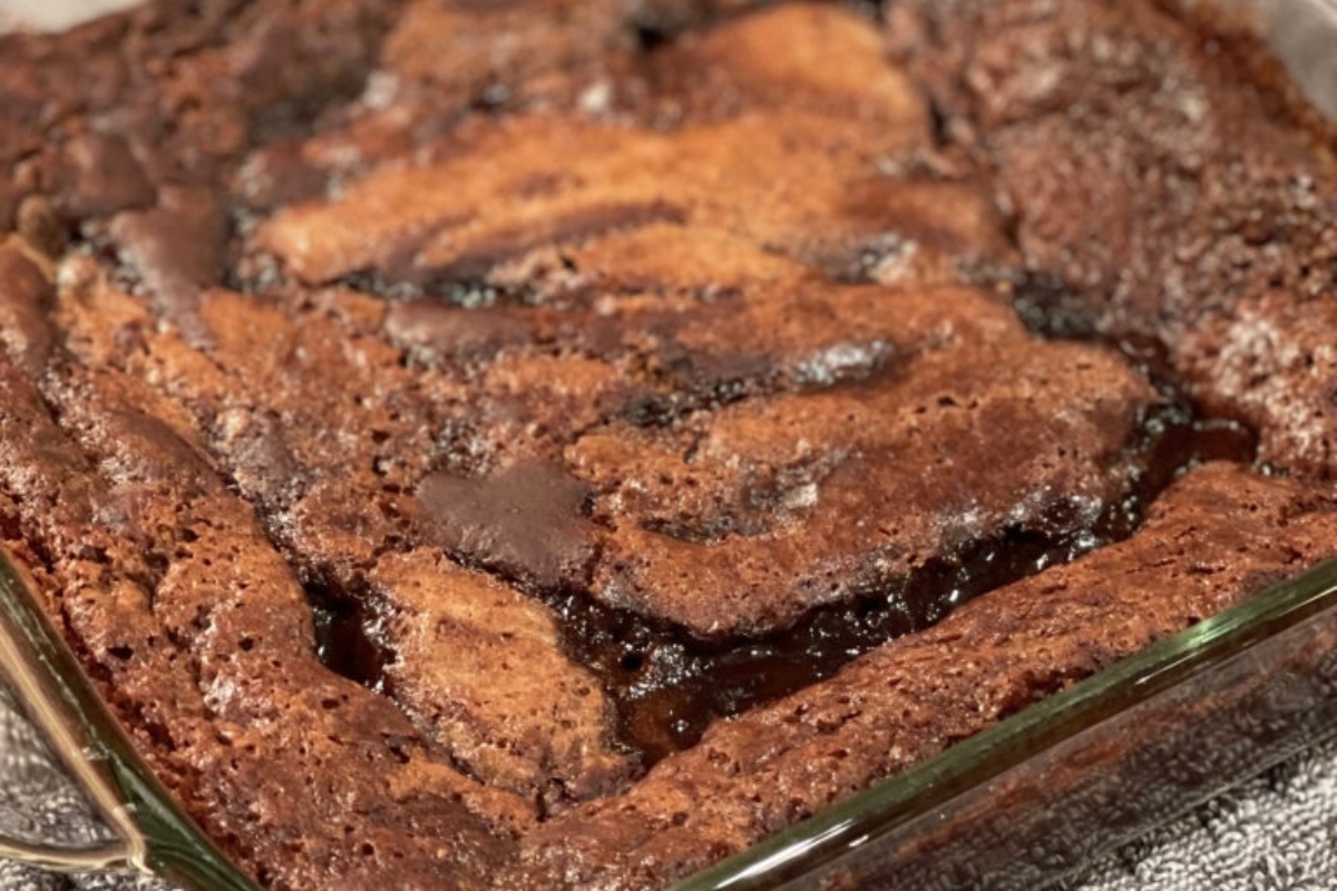 A fudge cake in a glass dish on a table.