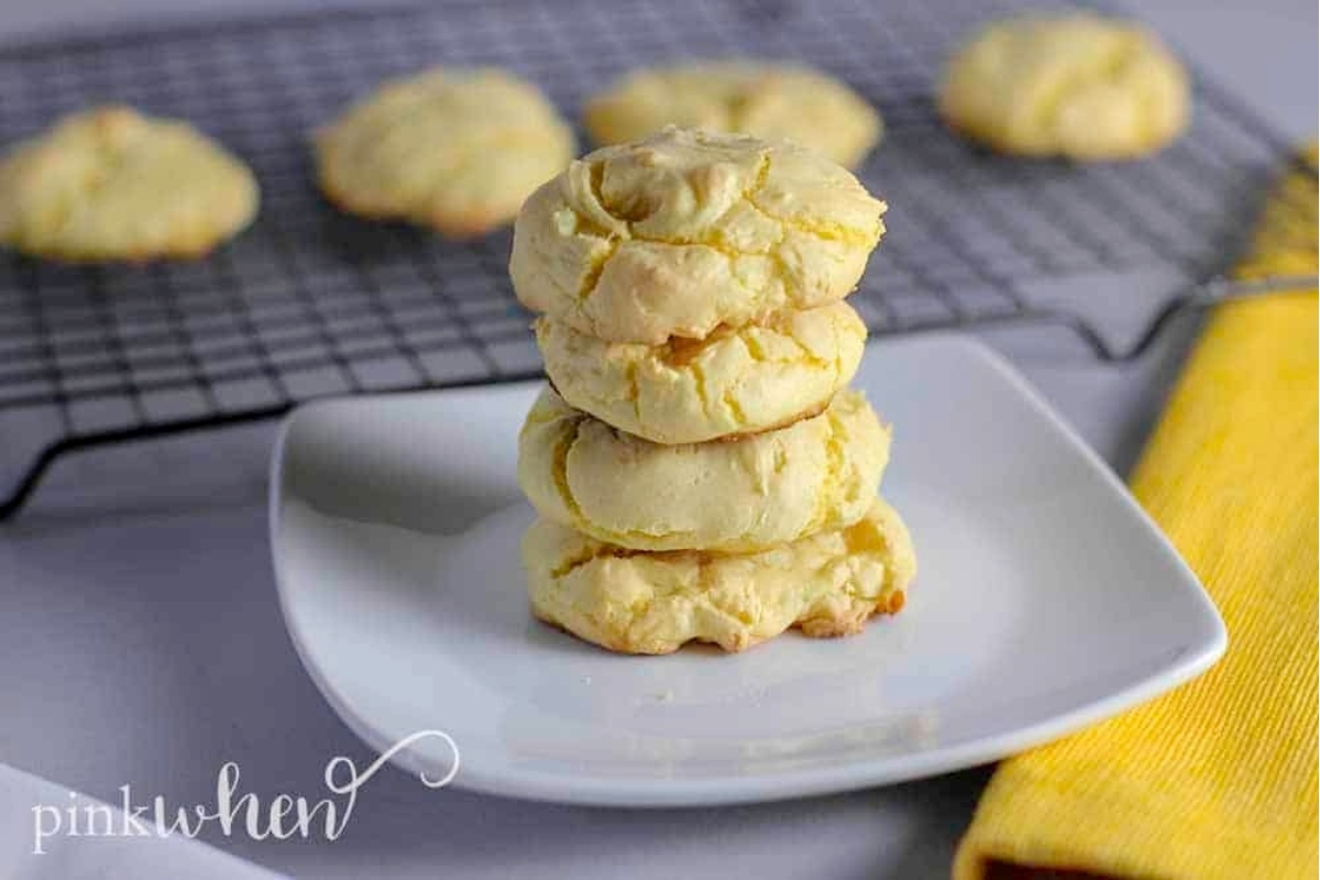 A stack of lemon cookies on a plate with a yellow napkin.