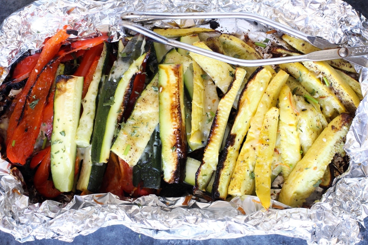 A tray of food with tongs.