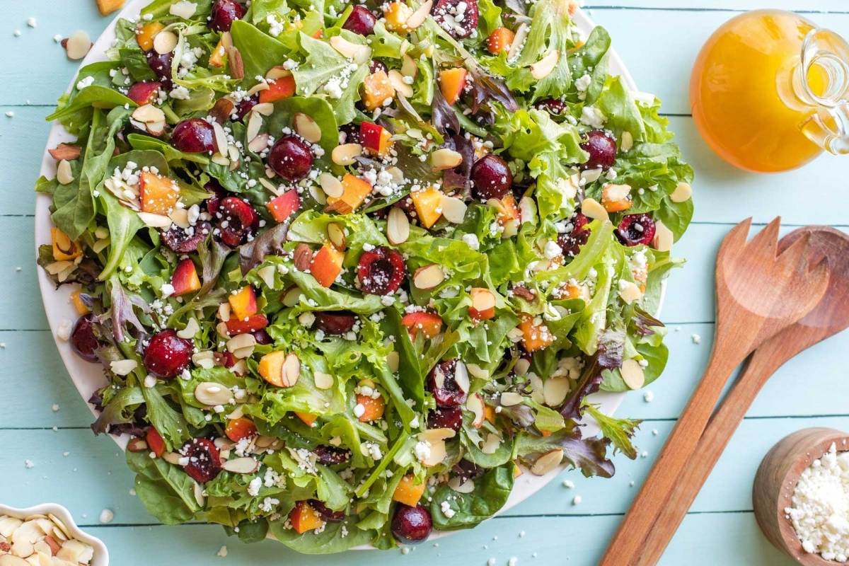 A salad with cranberries and nuts on a plate.