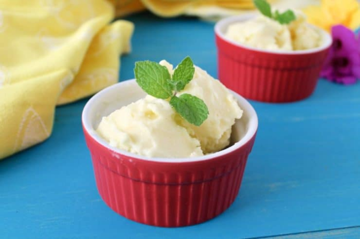 Two bowls of pineapple sorbet with mint leaves in them.