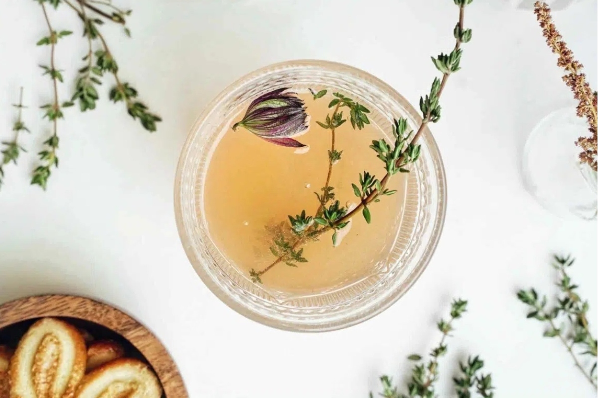 Broth with thyme and herbs on a table.