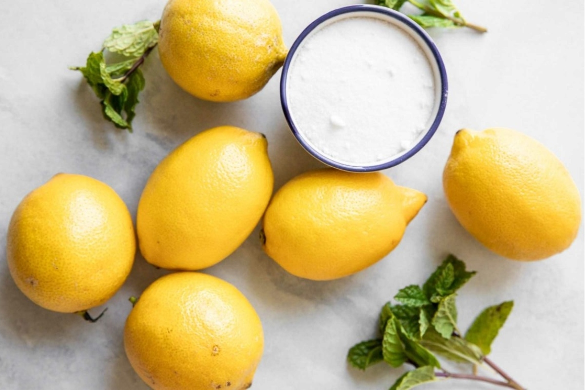 A bowl of lemon juice with mint leaves.