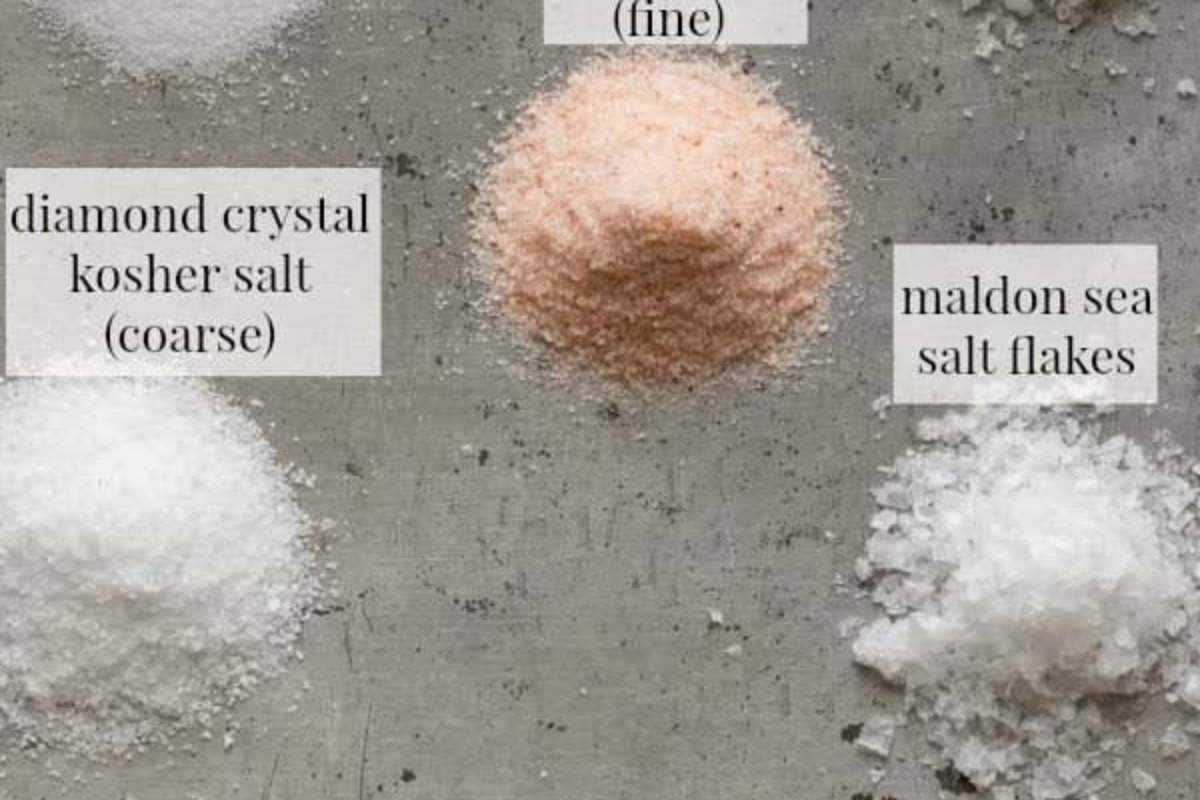 Various types of salt are shown on a concrete surface.