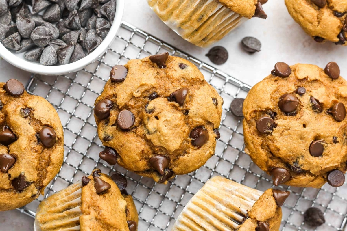Pumpkin chip muffins on a cooling rack with chocolate chips.