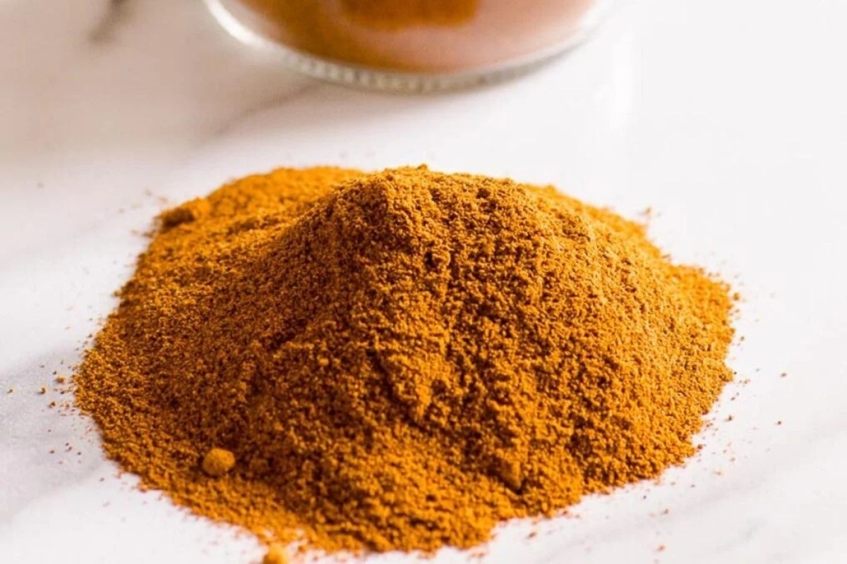 A pile of cinnamon powder on a white table.