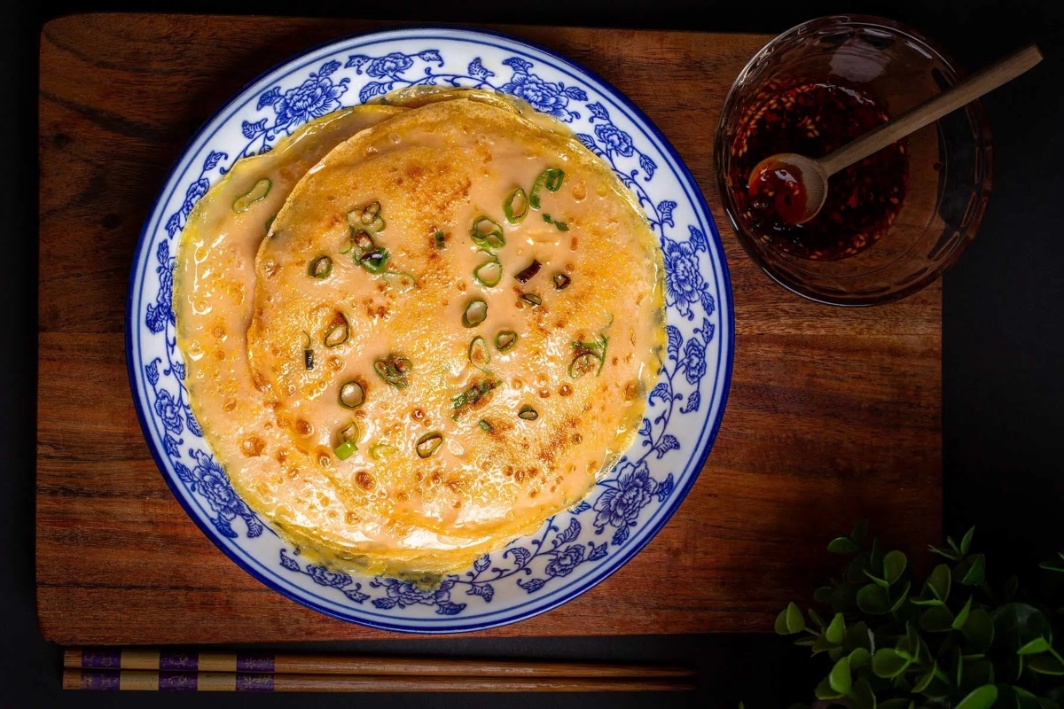 Food on a plate next to a bowl of sauce.