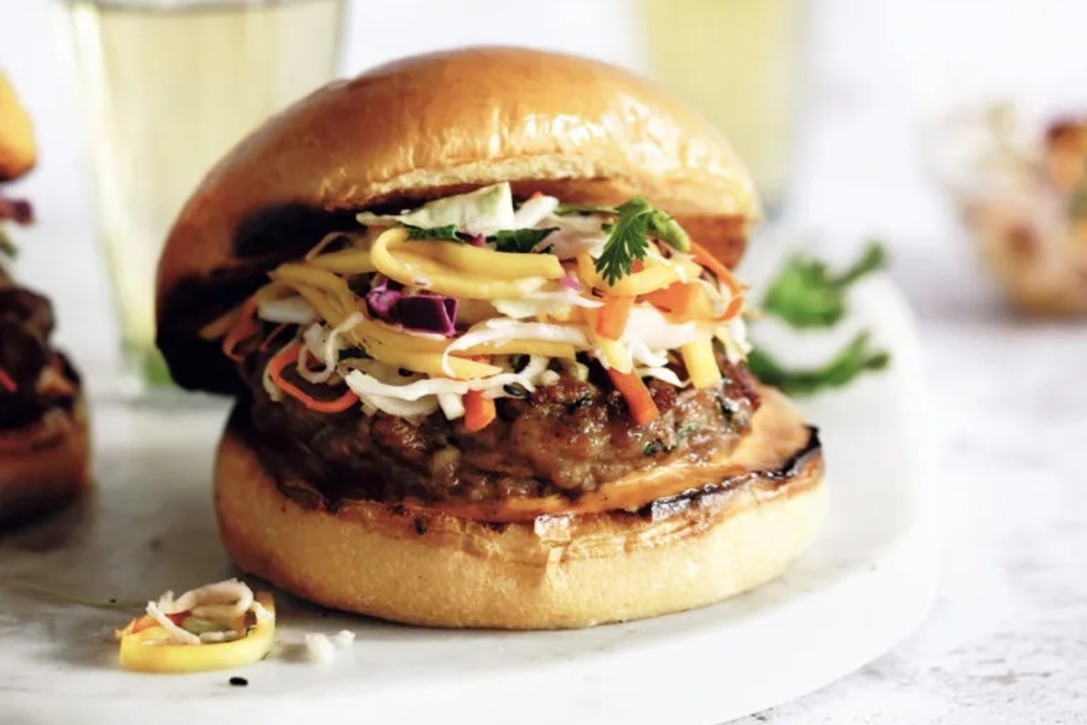 Two burgers with coleslaw on a plate.