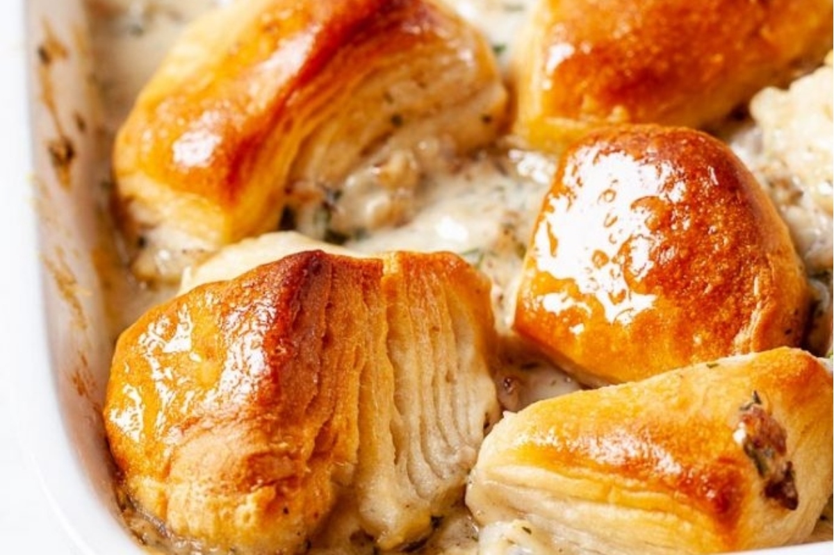 Golden-browned scallops in a creamy sauce served in a white dish.