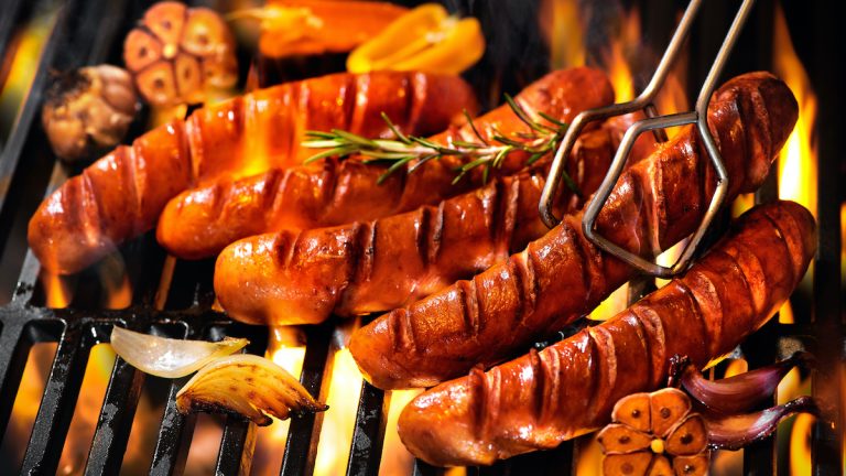 Grilled sausage on the flaming grill