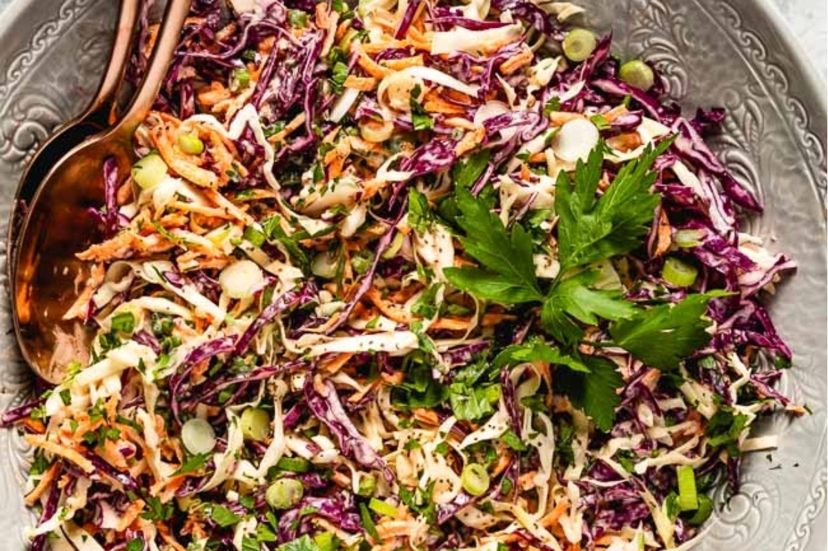 A bowl of coleslaw with a spoon.