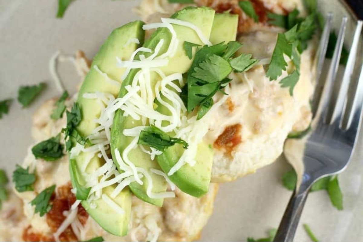 An avocado-topped dish garnished with cheese and cilantro.