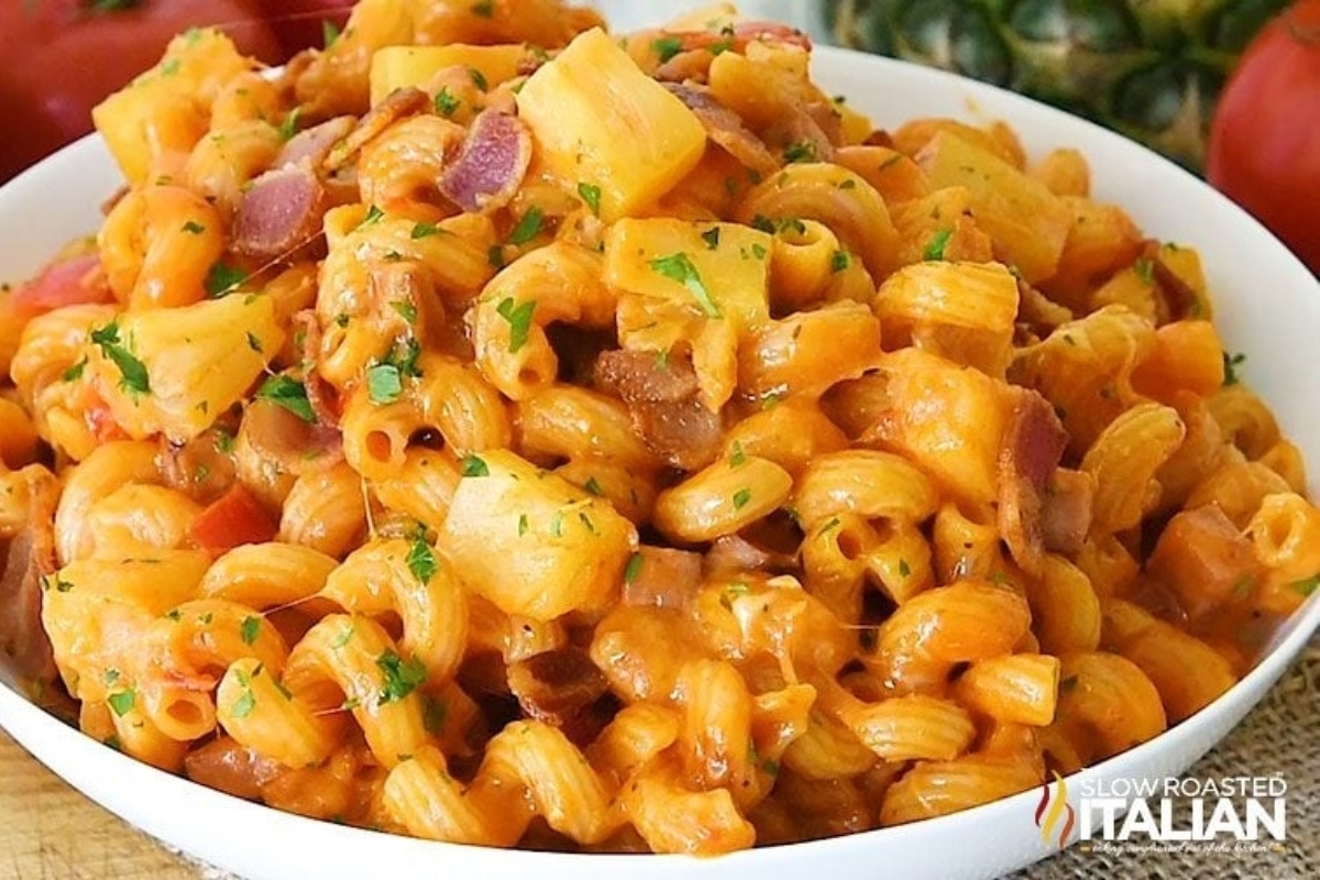 A plate of creamy pasta with ham and parsley garnish.