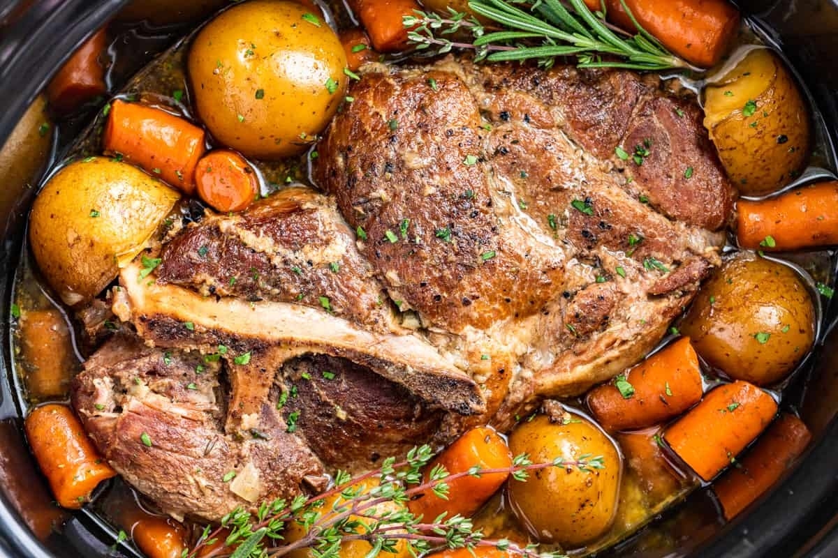 A crock pot full of meat, potatoes and carrots.