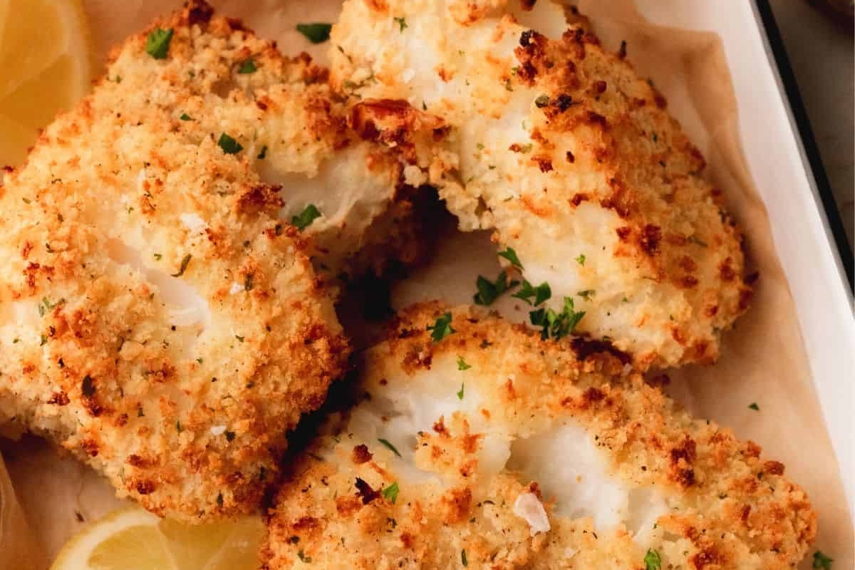 Golden-brown breaded fish fillets served with lemon and parsley.