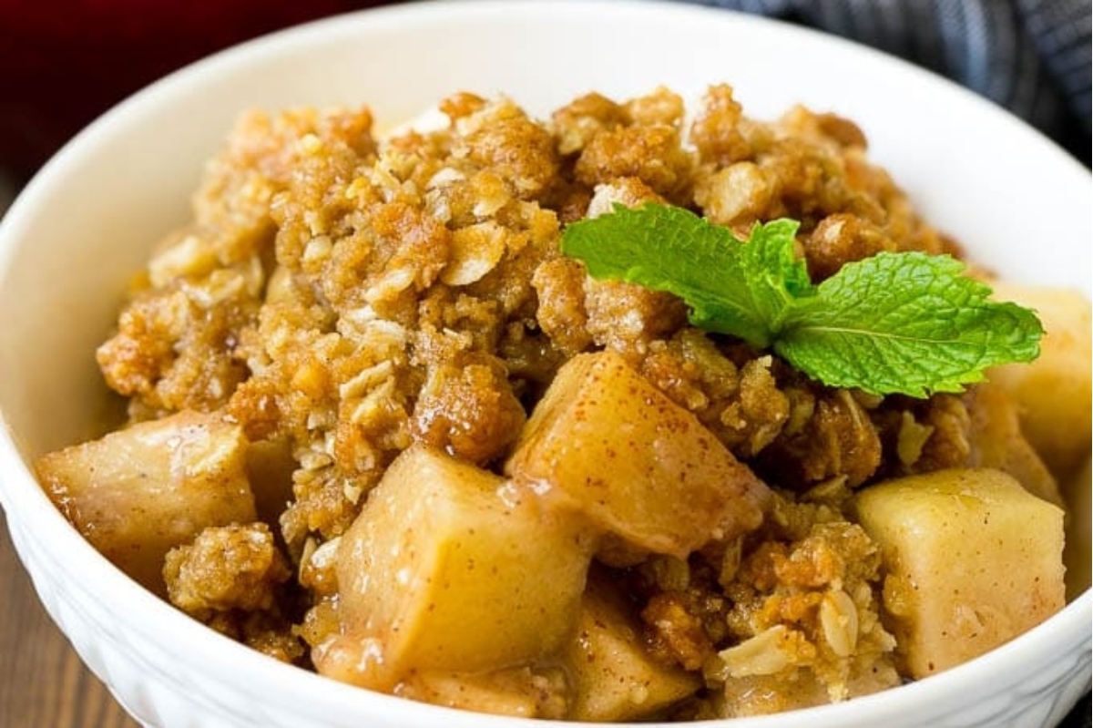 Apple crisp in a bowl with a mint leaf.