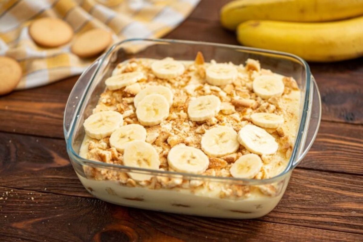 Banana pudding in a glass dish with bananas.