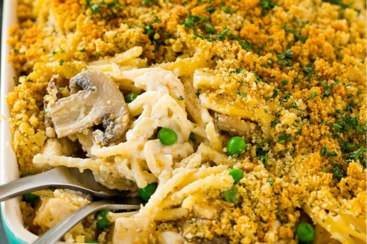 A casserole dish with chicken, peas and mushrooms.