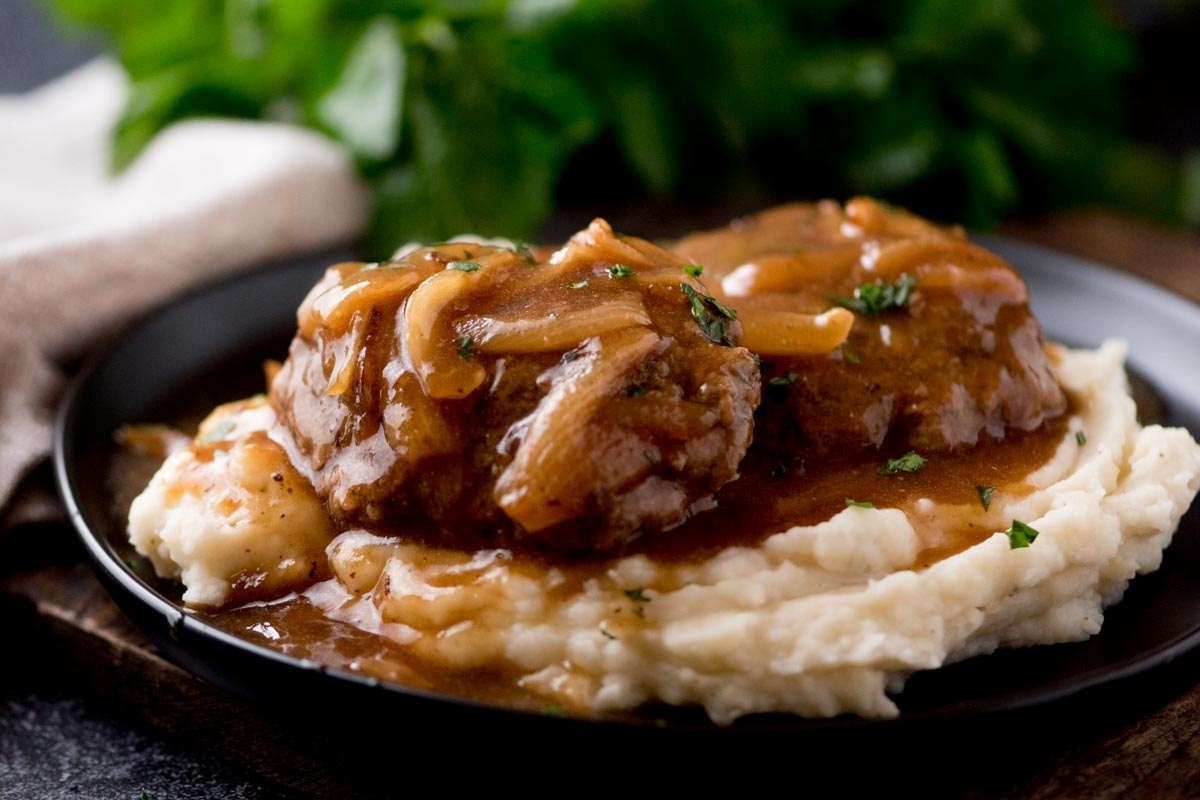 Steak with onion gravy served on mashed potatoes.