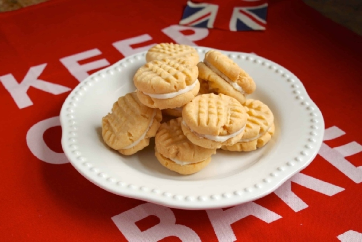 A plate of sandwich cookies on a red cloth with the text "keep calm" visible and a small british flag in the corner.