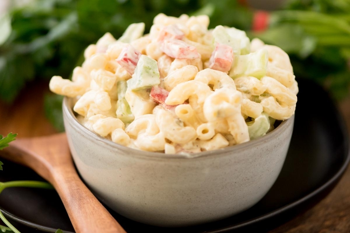 A bowl of macaroni salad with diced vegetables.