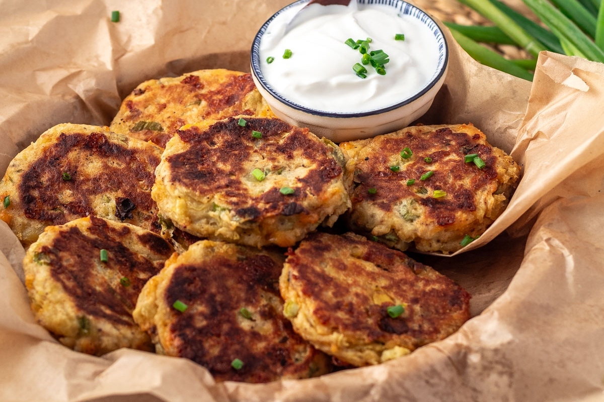 Golden-brown potato pancakes served with sour cream and garnished with chives.