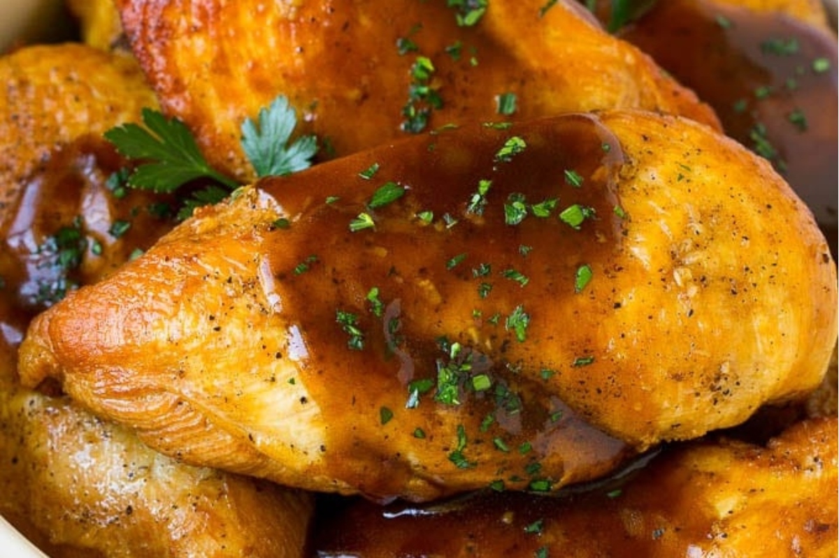 Roasted chicken pieces garnished with parsley and covered in gravy.