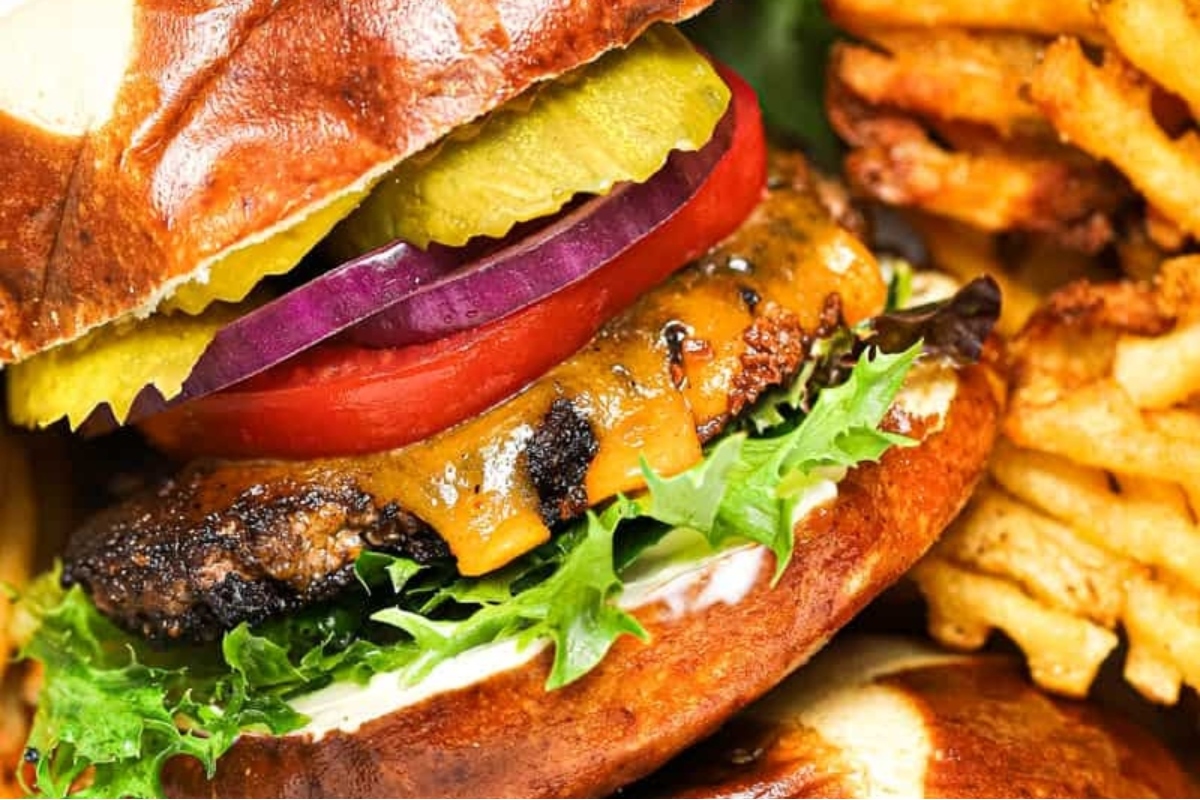 A burger with fries and tomatoes on a plate.