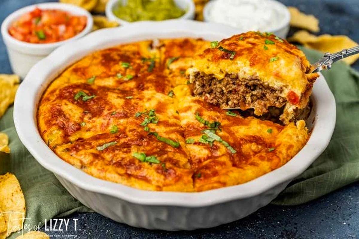 A freshly baked meat pie with a golden crust, a serving spoon lifting a portion, revealing the steamy, meaty interior, garnished with chopped herbs. various dips in the background.