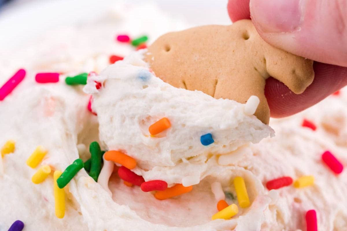 A cookie scooping some dip.