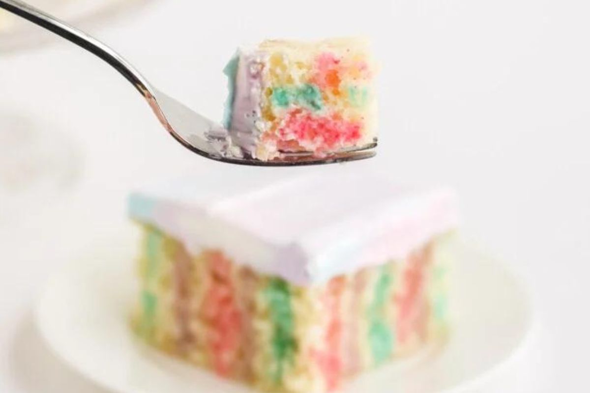 Slice of cake with fork bite held in the air.