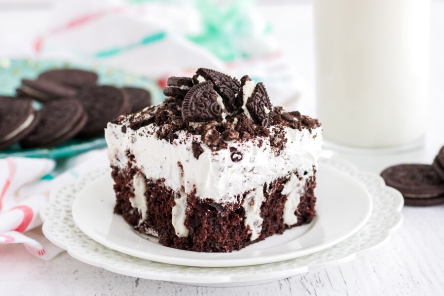 Slice of Oreo Poke Cake on white plate.